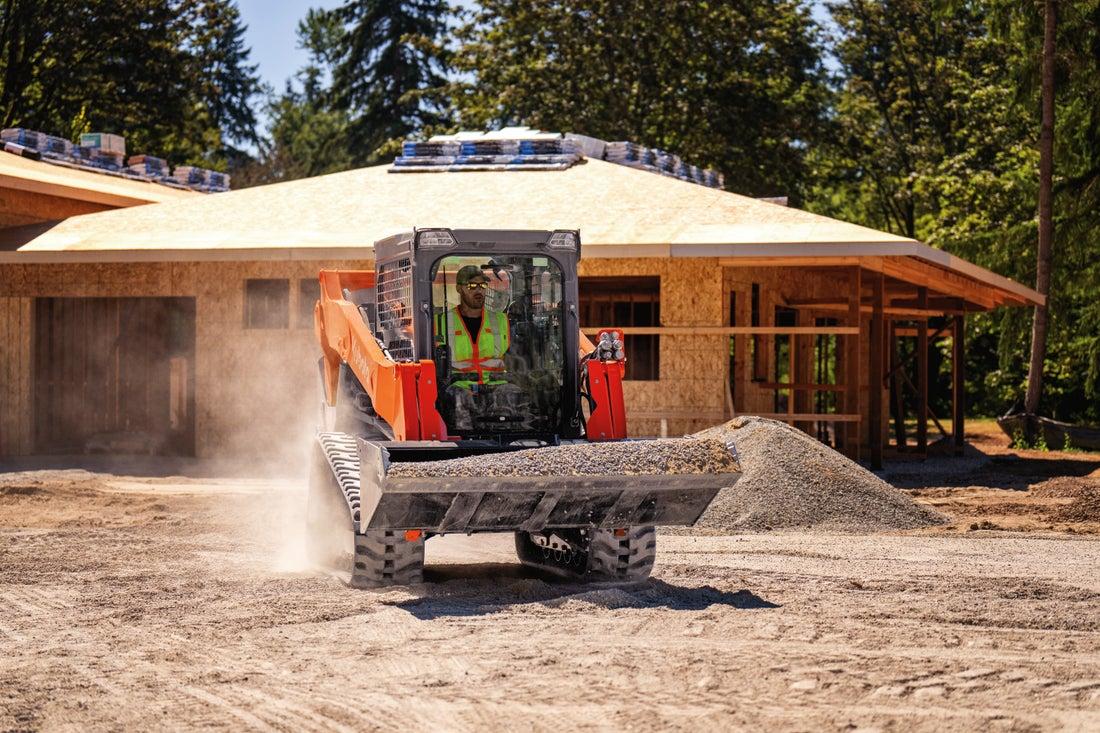 Man moving gravel with skid steer on a construction site