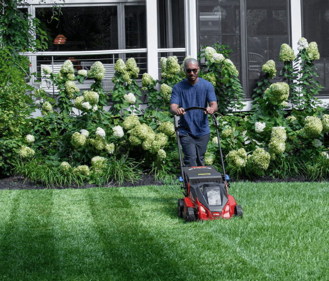 Man mowing yard with a push mower