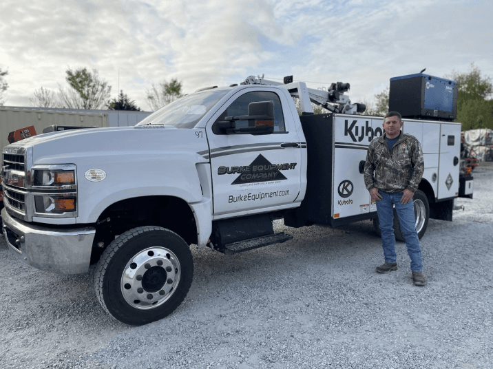 Employee standing in front of field service truck