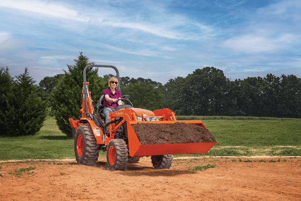 Woman moving dirt with front end loader
