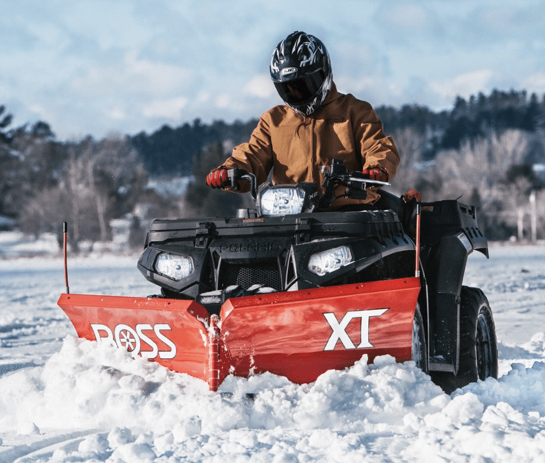 Person on an ATV with front snow plow attachment